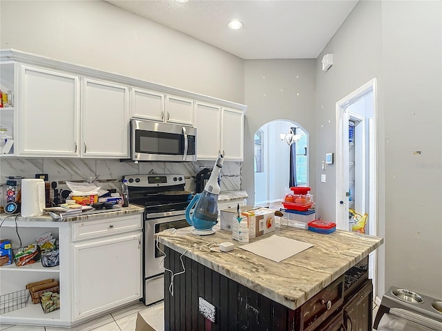 173 Portland Ave, Spring Hill, FL 34606 - kitchen featuring appliances with stainless steel finishes, white cabinetry, open shelves, a center island, and tasteful backsplash