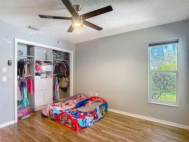 173 Portland Ave, Spring Hill, FL 34606 - bedroom featuring a textured ceiling, a closet, wood finished floors, and a ceiling fan