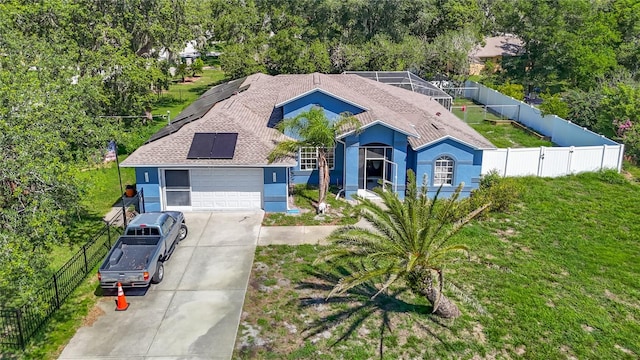 173 Portland Ave, Spring Hill, FL 34606 - view of front of home with roof mounted solar panels, concrete driveway, stucco siding, and a fenced backyard