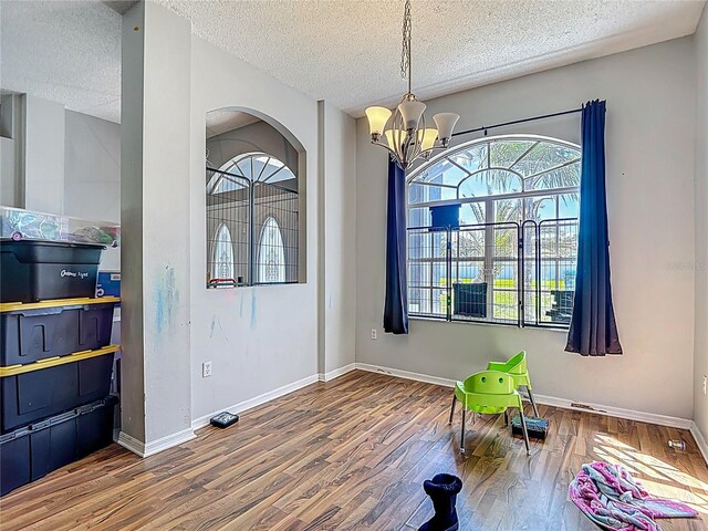 173 Portland Ave, Spring Hill, FL 34606 - foyer featuring a textured ceiling, wood finished floors, a chandelier, and arched walkways