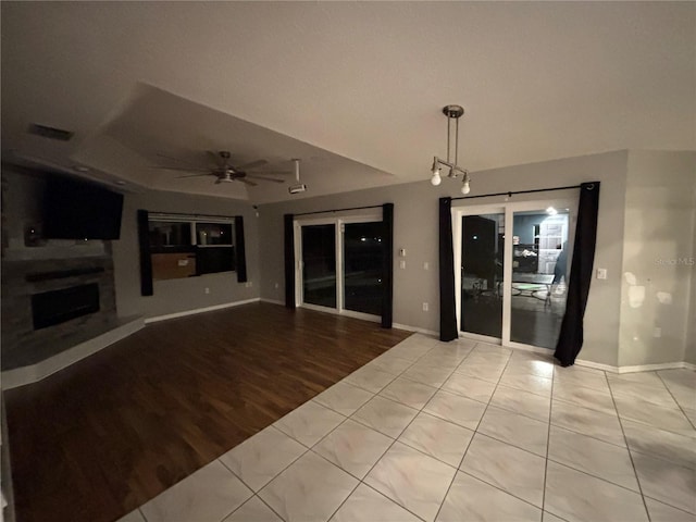 173 Portland Ave, Spring Hill, FL 34606 - unfurnished living room with a ceiling fan, a fireplace with raised hearth, and wood finished floors