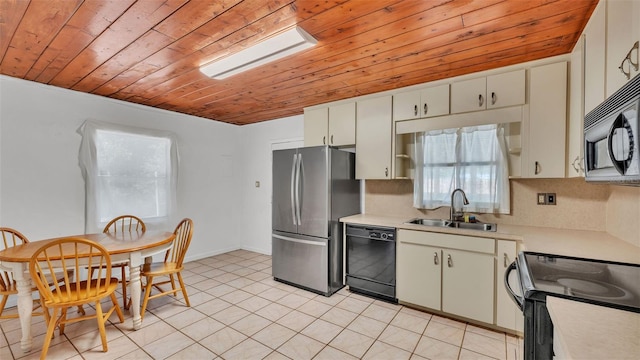 712 N Gary Rd, Lakeland, FL 33801 - kitchen with black appliances, wood ceiling, light countertops, light tile patterned floors, and white cabinets