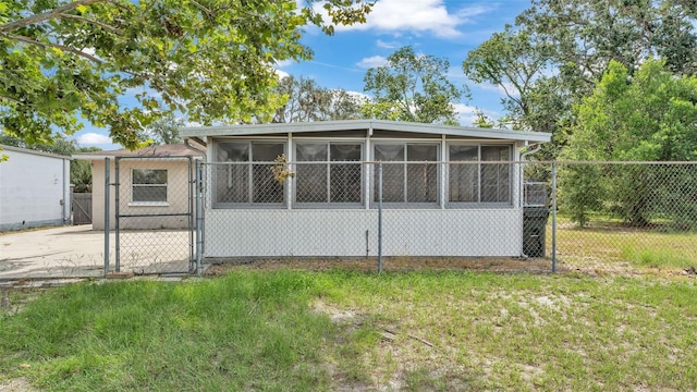 712 N Gary Rd, Lakeland, FL 33801 - rear view of property with a gate and a sunroom