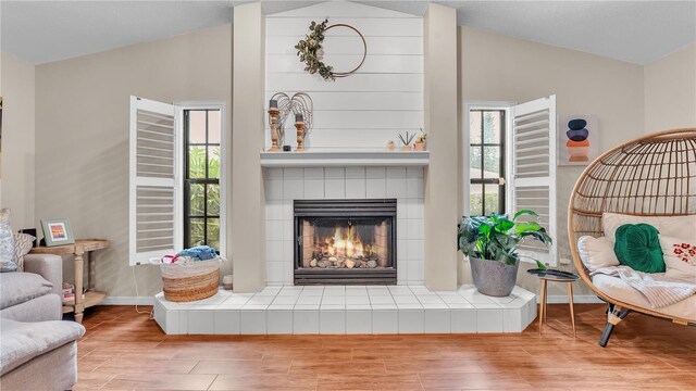 5819 Hollyhock Dr, Lakeland, FL 33813 - living area with lofted ceiling, a tile fireplace, and wood finished floors