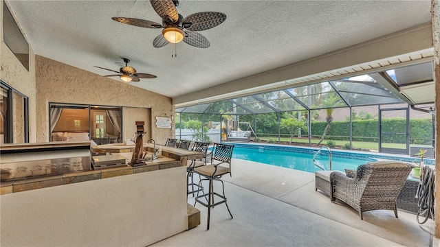 5819 Hollyhock Dr, Lakeland, FL 33813 - outdoor pool featuring a bar, a patio, glass enclosure, and a ceiling fan