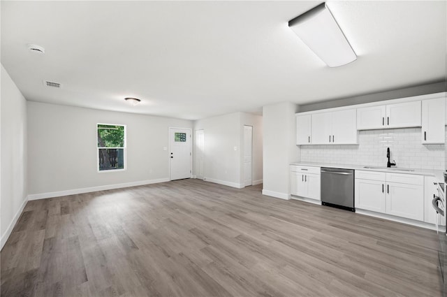 2633 Keysville Dr, Lithia, FL 33547 - kitchen featuring stainless steel dishwasher, light countertops, tasteful backsplash, light wood finished floors, and white cabinetry