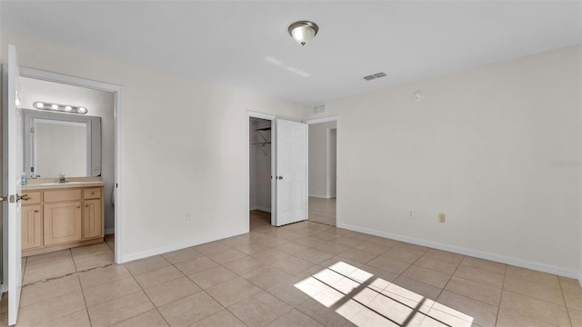 4515 Starfish Ave, Sebring, FL 33870 - unfurnished bedroom featuring light tile patterned floors, a closet, ensuite bath, and a spacious closet