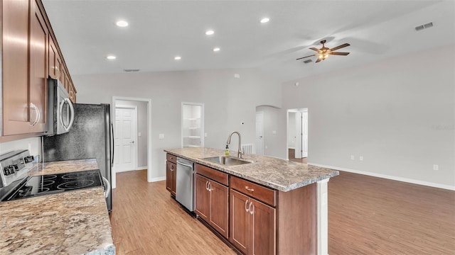 4143 Red Fern Ln, Lakeland, FL 33811 - kitchen featuring appliances with stainless steel finishes, a ceiling fan, a center island with sink, light wood-type flooring, and lofted ceiling