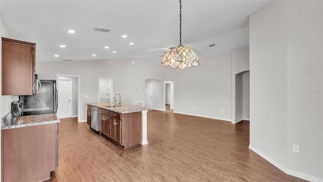 4143 Red Fern Ln, Lakeland, FL 33811 - kitchen with arched walkways, appliances with stainless steel finishes, light wood-style flooring, a kitchen island with sink, and recessed lighting