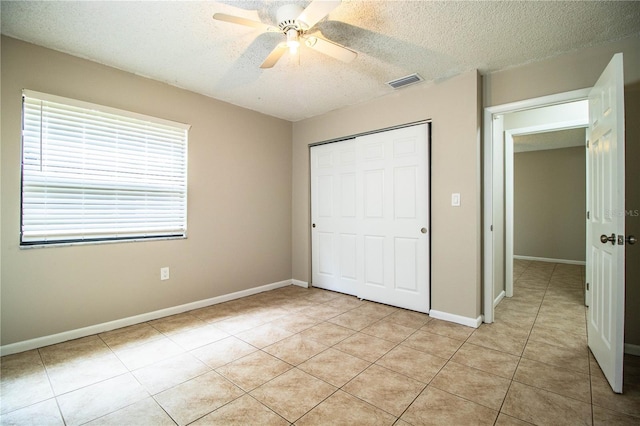 3582 Raintree Ct, Lakeland, FL 33803 - unfurnished bedroom with a textured ceiling, light tile patterned floors, a closet, and a ceiling fan