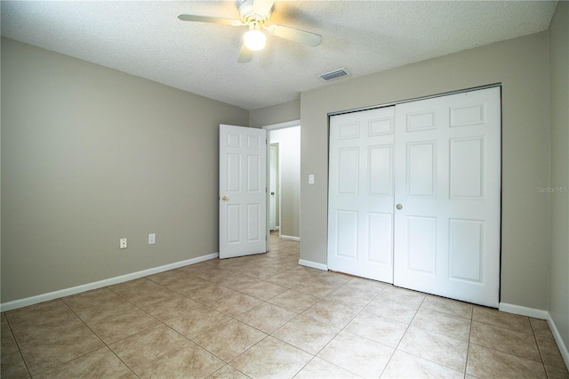3582 Raintree Ct, Lakeland, FL 33803 - unfurnished bedroom featuring a textured ceiling, a closet, light tile patterned floors, and a ceiling fan