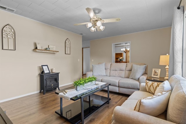 3521 Publix Rd, Lakeland, FL 33810 - living area with a wood stove, ceiling fan, a chandelier, and wood finished floors