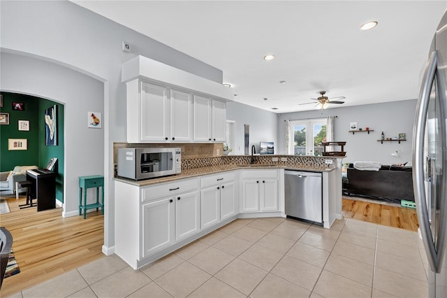 1026 Mohawk Ave NW, Palm Bay, FL 32907 - kitchen featuring stainless steel appliances, light tile patterned floors, a ceiling fan, white cabinetry, and open floor plan