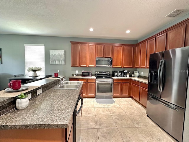 13303 Moss Park Ridge Dr, Orlando, FL 32832 - kitchen with stainless steel appliances, light tile patterned flooring, recessed lighting, brown cabinets, and a textured ceiling