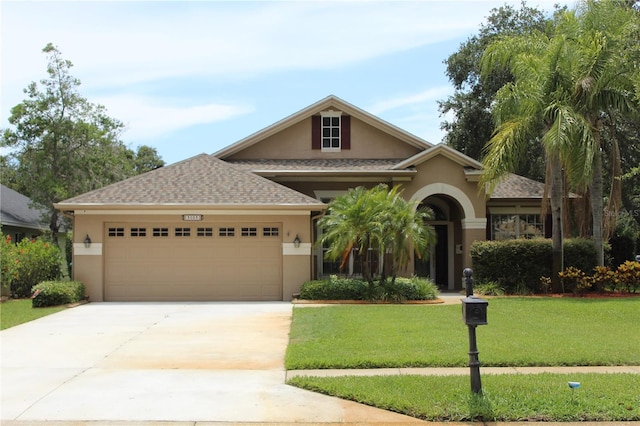 3023 Northfield Dr, Tarpon Springs, FL 34688 - view of front facade featuring stucco siding, a garage, a front yard, driveway, and roof with shingles