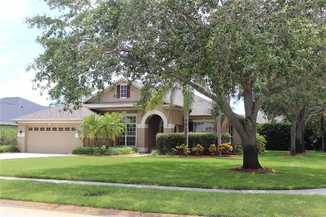 3023 Northfield Dr, Tarpon Springs, FL 34688 - view of front facade with stucco siding, an attached garage, a front lawn, and concrete driveway