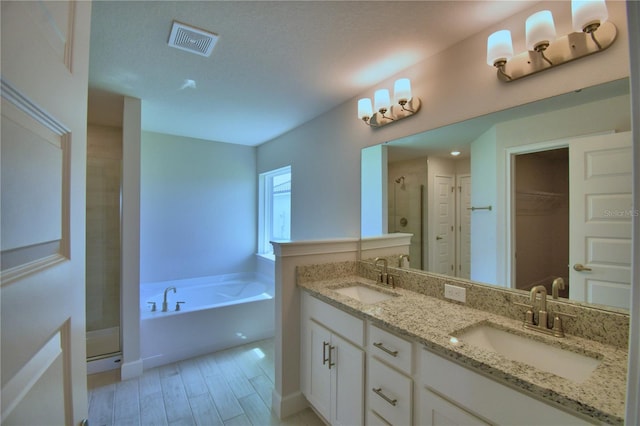 5427 Waterside Dr, Auburndale, FL 33823 - bathroom with a stall shower, a bath, double vanity, a walk in closet, and wood finished floors
