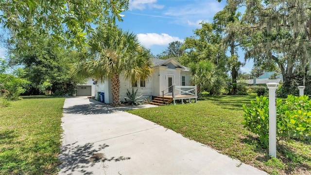 423 Ave H SE, Winter Haven, FL 33880 - view of front of house featuring concrete driveway, a front yard, and an attached garage
