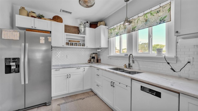 423 Ave H SE, Winter Haven, FL 33880 - kitchen featuring stainless steel fridge, dishwasher, white cabinetry, open shelves, and light stone counters