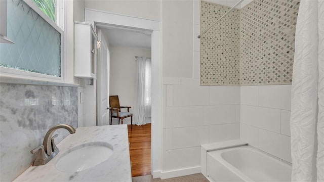 423 Ave H SE, Winter Haven, FL 33880 - full bathroom with shower / tub combo, tile walls, wood finished floors, healthy amount of natural light, and vanity