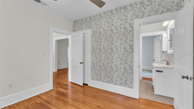 423 Ave H SE, Winter Haven, FL 33880 - empty room featuring wallpapered walls, ceiling fan, and light wood-style floors