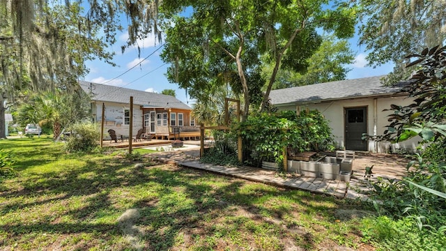 423 Ave H SE, Winter Haven, FL 33880 - view of grassy yard with a garden, a deck, and a patio area