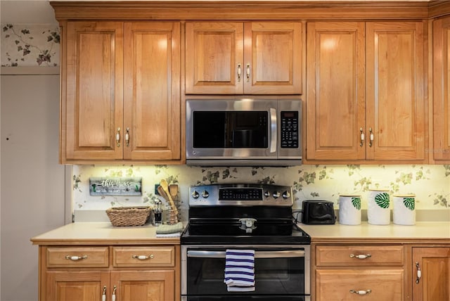 521 Lone Palm Dr, Lakeland, FL 33815 - kitchen featuring appliances with stainless steel finishes, light countertops, and brown cabinetry