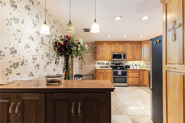 521 Lone Palm Dr, Lakeland, FL 33815 - kitchen with stainless steel appliances, wallpapered walls, pendant lighting, recessed lighting, and light countertops