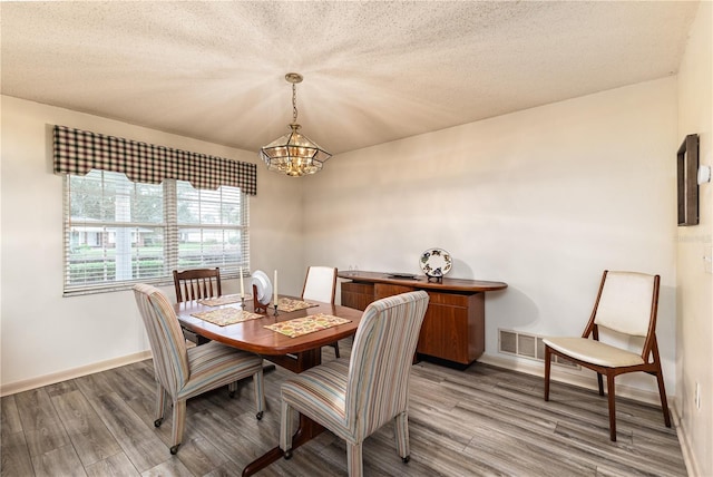 521 Lone Palm Dr, Lakeland, FL 33815 - dining space featuring a chandelier, light wood-type flooring, and a textured ceiling