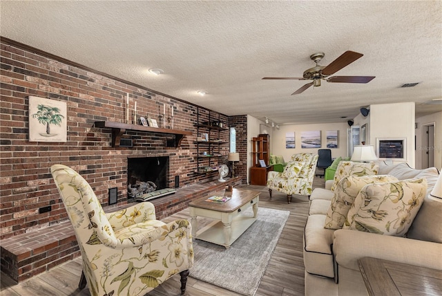 521 Lone Palm Dr, Lakeland, FL 33815 - living room with ceiling fan, a textured ceiling, wood finished floors, a brick fireplace, and brick wall