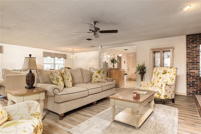 521 Lone Palm Dr, Lakeland, FL 33815 - living area featuring a textured ceiling, a ceiling fan, wood finished floors, and a chandelier