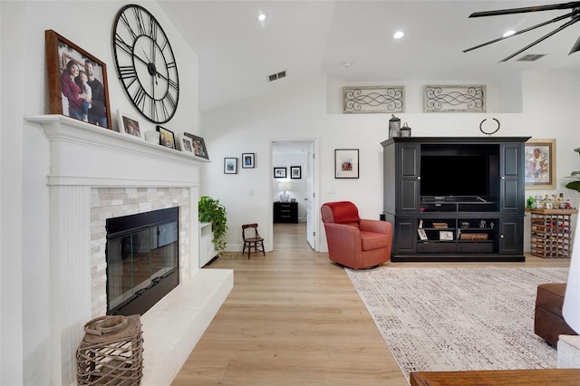 122 Amber Blvd, Auburndale, FL 33823 - living area with a tiled fireplace, wood finished floors, high vaulted ceiling, and recessed lighting