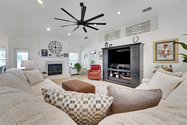 122 Amber Blvd, Auburndale, FL 33823 - living area with light wood-style flooring, ceiling fan, vaulted ceiling, a glass covered fireplace, and recessed lighting