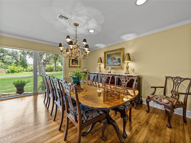 2213 Woodbine Ave, Lakeland, FL 33803 - dining space featuring wood finished floors, ornamental molding, and a chandelier