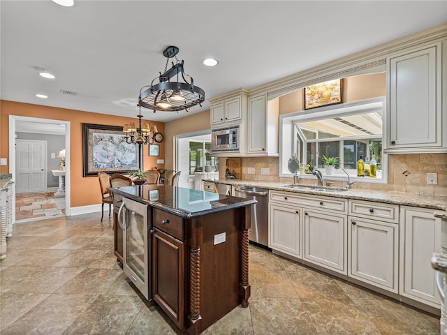 2213 Woodbine Ave, Lakeland, FL 33803 - kitchen with appliances with stainless steel finishes, decorative backsplash, a chandelier, cream cabinetry, and recessed lighting