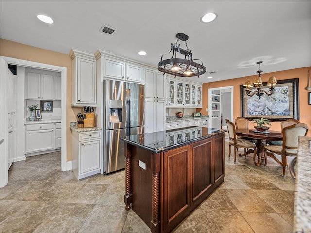 2213 Woodbine Ave, Lakeland, FL 33803 - kitchen featuring stainless steel refrigerator with ice dispenser, dark stone counters, a chandelier, glass insert cabinets, and decorative light fixtures