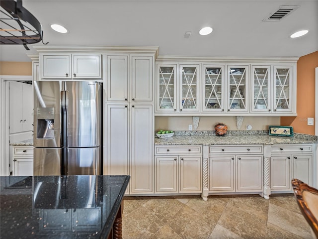 2213 Woodbine Ave, Lakeland, FL 33803 - kitchen with stainless steel refrigerator with ice dispenser, glass insert cabinets, light stone countertops, and white cabinets