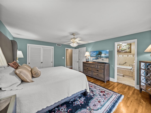 2213 Woodbine Ave, Lakeland, FL 33803 - bedroom featuring wood finished floors, two closets, a ceiling fan, and connected bathroom