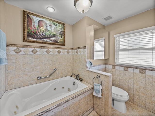 2213 Woodbine Ave, Lakeland, FL 33803 - full bath with tile walls, a jetted tub, a wainscoted wall, and tile patterned floors