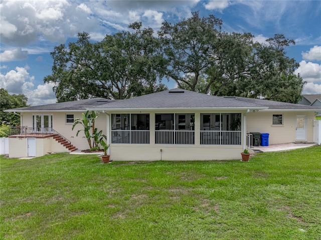 2213 Woodbine Ave, Lakeland, FL 33803 - back of house featuring a sunroom, a lawn, stairs, and a patio