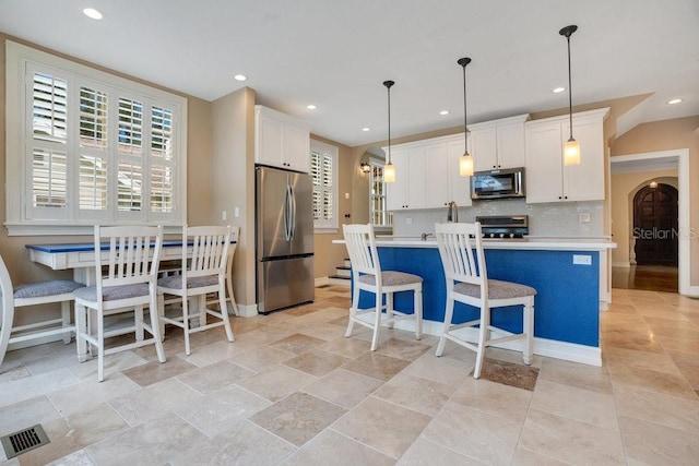 207 W Maxwell St, Lakeland, FL 33803 - kitchen with appliances with stainless steel finishes, light countertops, white cabinets, an island with sink, and recessed lighting