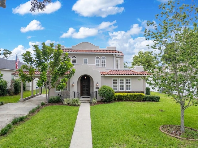 207 W Maxwell St, Lakeland, FL 33803 - mediterranean / spanish-style home featuring stucco siding, a tiled roof, a front lawn, and concrete driveway
