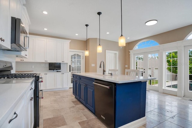207 W Maxwell St, Lakeland, FL 33803 - kitchen featuring stainless steel appliances, blue cabinets, white cabinets, stone tile floors, and recessed lighting