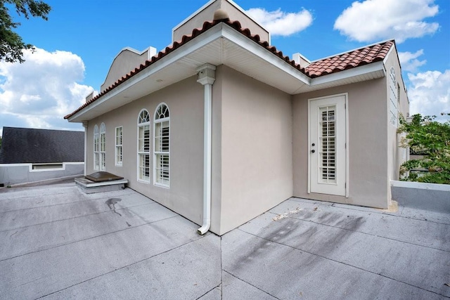 207 W Maxwell St, Lakeland, FL 33803 - back of house featuring a tile roof, a patio, and stucco siding