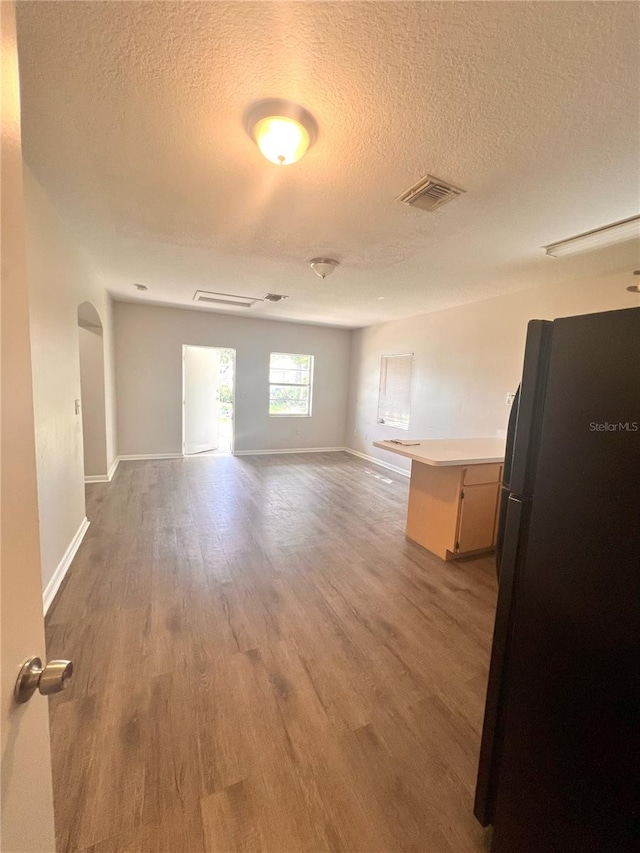 132 Mckean St Unit A, B, Auburndale, FL 33823 - spare room featuring a textured ceiling, wood finished floors, and arched walkways