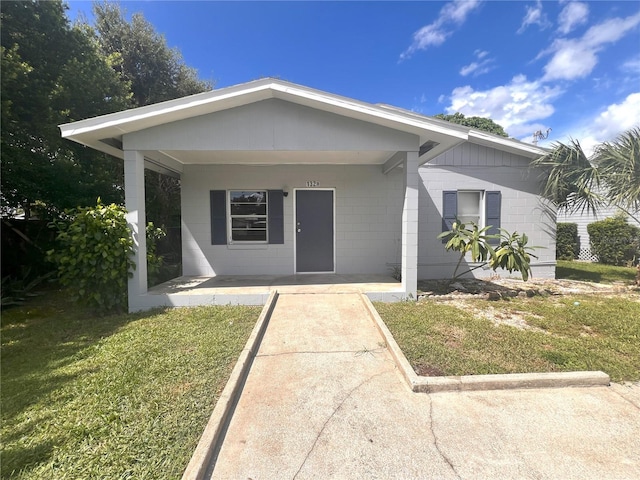 132 Mckean St Unit A, B, Auburndale, FL 33823 - view of front of home featuring concrete block siding, covered porch, and a front yard