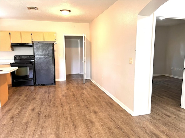 132 Mckean St Unit A, B, Auburndale, FL 33823 - kitchen featuring black appliances, under cabinet range hood, light wood finished floors, and light countertops