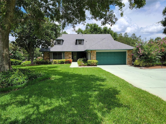 1842 Pinnacle Dr, Lakeland, FL 33813 - new england style home featuring stone siding, driveway, an attached garage, a front lawn, and a shingled roof