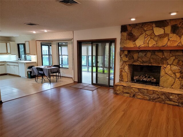 1842 Pinnacle Dr, Lakeland, FL 33813 - living area with light wood-style flooring, a textured ceiling, and a fireplace