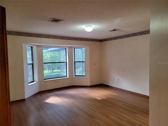 1842 Pinnacle Dr, Lakeland, FL 33813 - spare room with wood finished floors and a textured ceiling